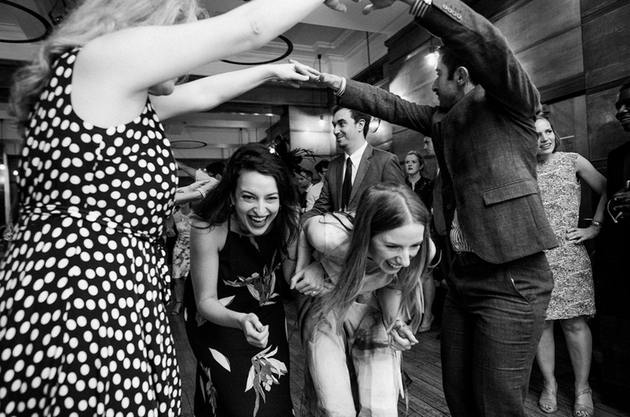 black and white image of wedding guests performing a ceilidh.