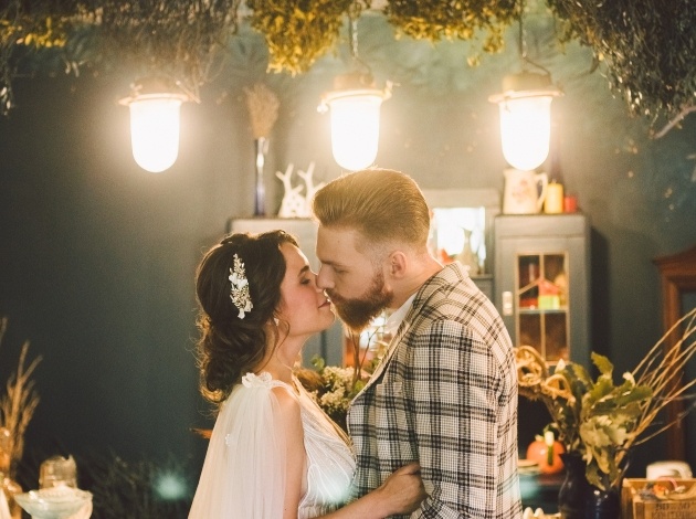 couple on wedding day in doors candle light groom in checked jacket 