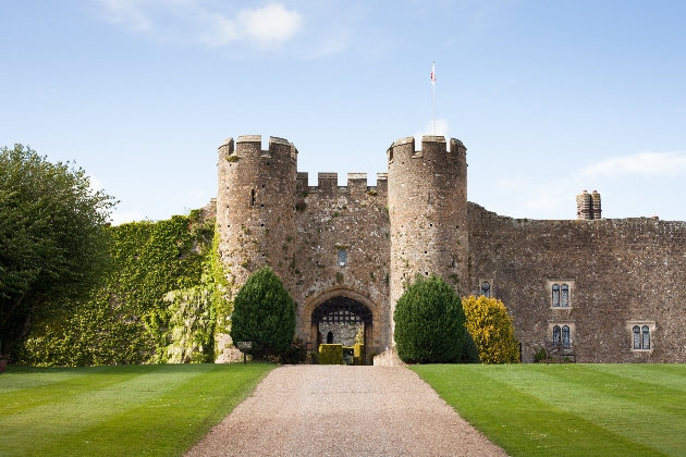 castle at the end of a drive with mowed lawns