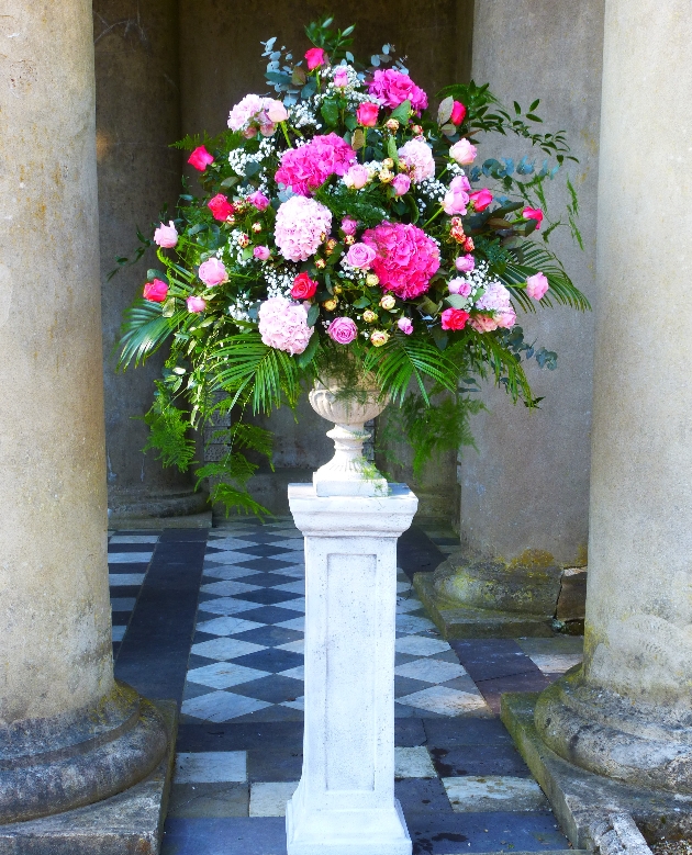 large pedestal arrangement of flowers in an urn