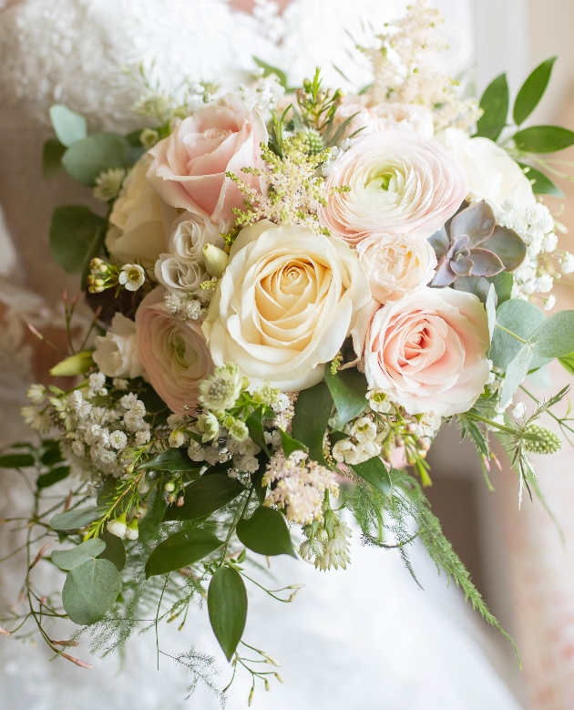 close up image of a bridal bouquet of peach and white flowers