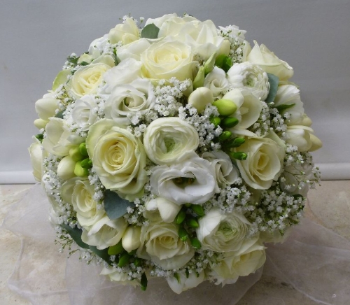 close up image of a round bridal bouquets of white flowers
