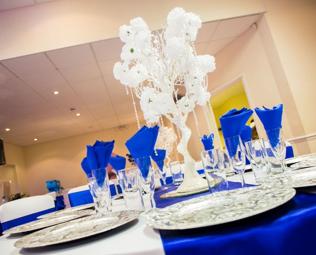 white trees with hanging crystals on a table with a blue runner