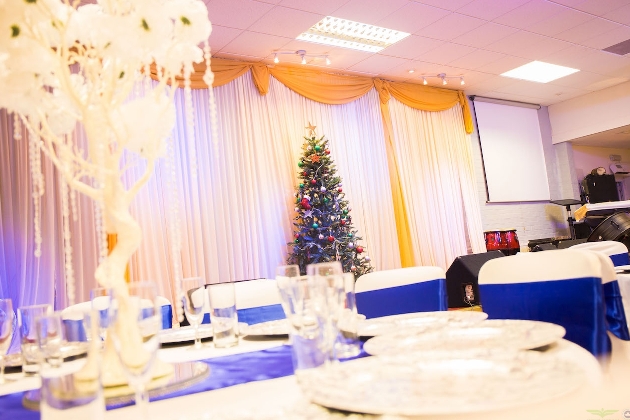 white themed wedding reception room with christmas tree in the background