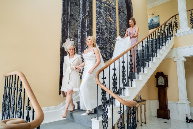 mother of the bride helping the bride down the stairs