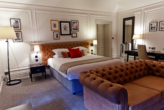 hotel room with king size bed and leather sofa country luxe style
