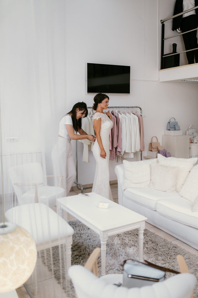 bride in a wedding dress standing in a dress boutique