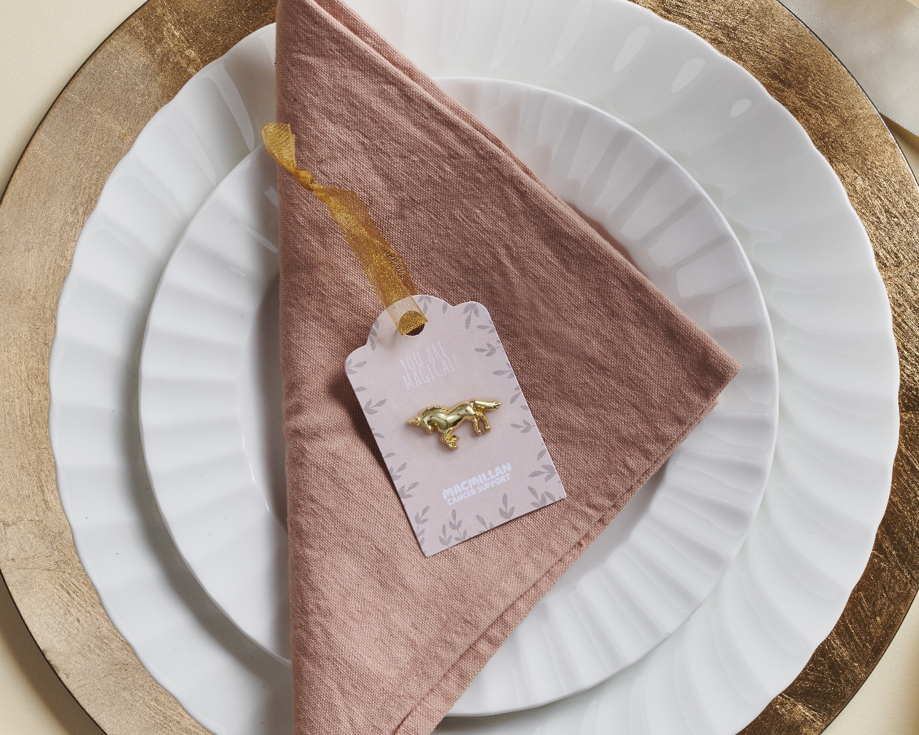 gold unicorn pin badge on a napkin