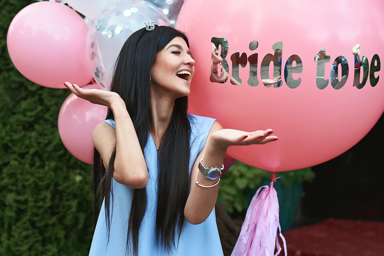 bride to be in blue top in front of balloons 