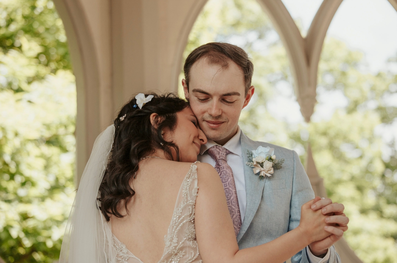 Bride resting head on groom's shoulder