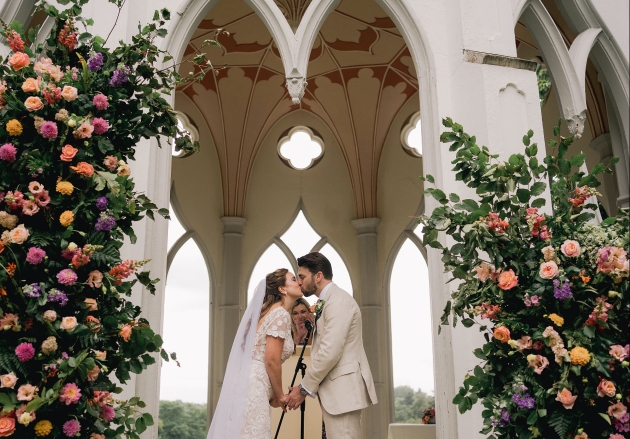 Couple getting married under The Gothic Temple at Painshill