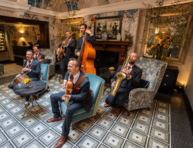 group of musician sat in different armchairs playing their instruments