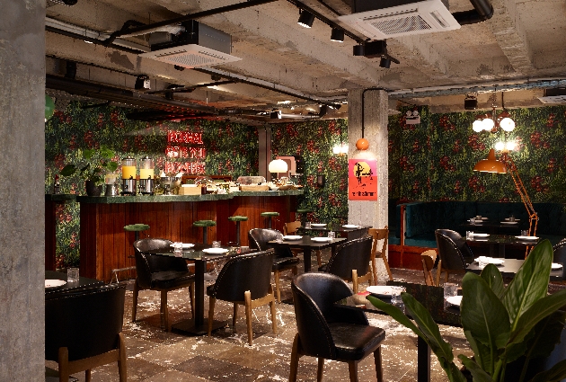 concrete pillars and expose industrial ceiling, jungle wallpaper, bar with table sand chairs
