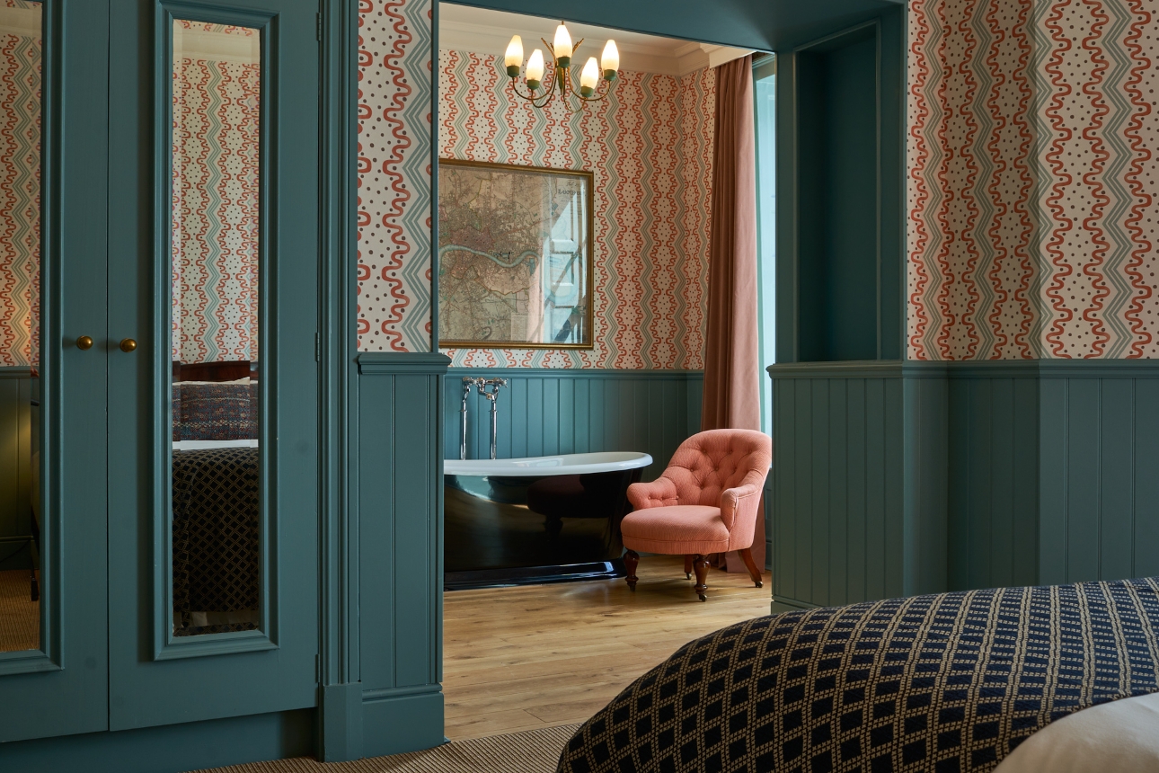 room with separate bathroom suite, blue panelled bottom, with patterned paper at top around the room