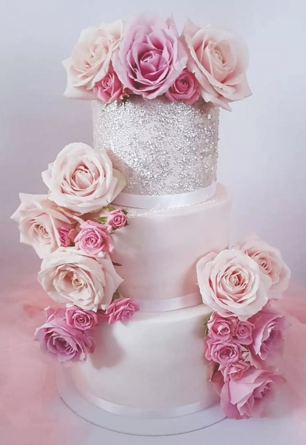 three-tier white cake, top tier sparkle silver, all covered in pink roses