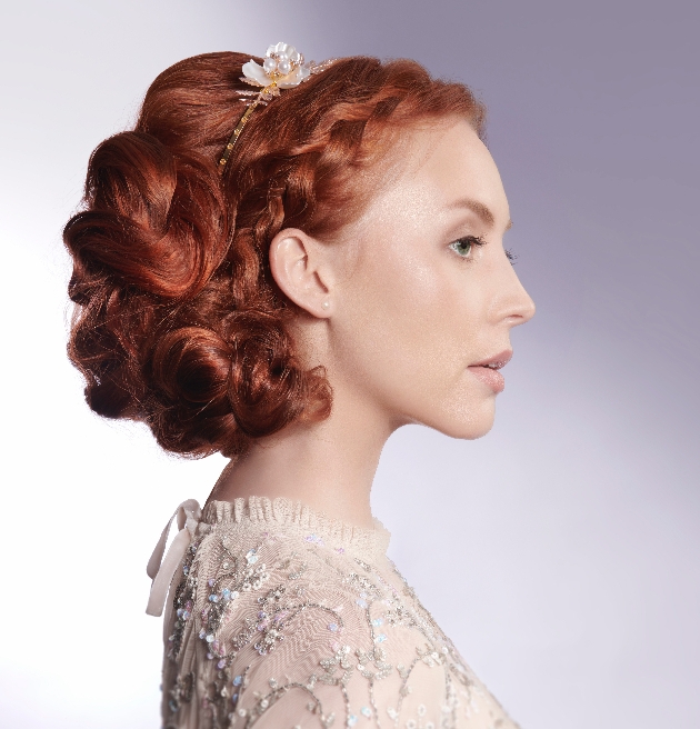 model in wedding top hair up in curls and plait, with gold and pearl headband on