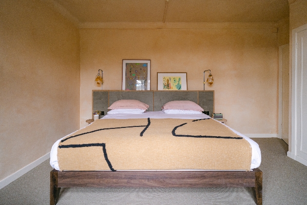 bed in room with walls and ceilings with a beige plaster effect