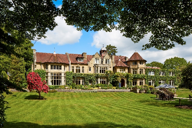 historic house surrounded by garden lawn and trees