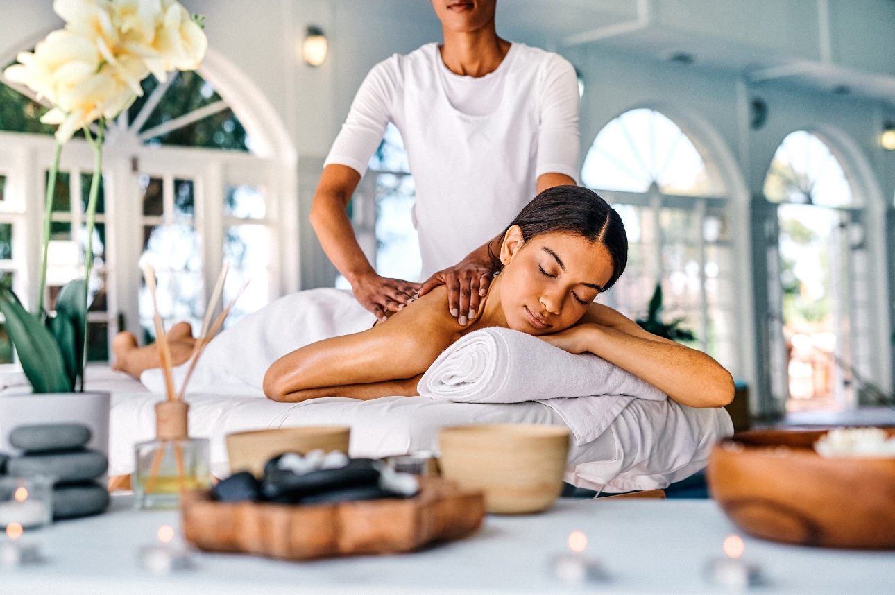 woman laying on a bed having a massage in a spa