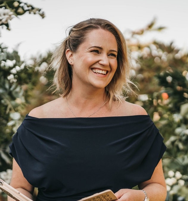 head shot of helen at a wedding holding book