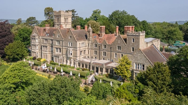 historic pale stone house in midst of trees