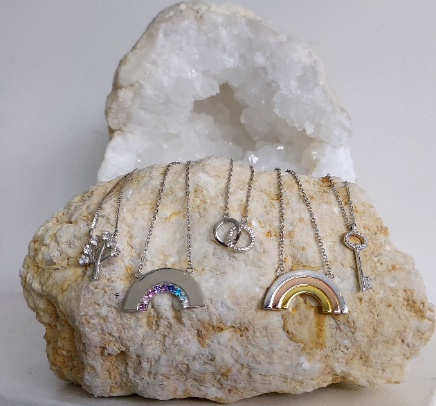 silver pendants and chains displayed on a crystal rock