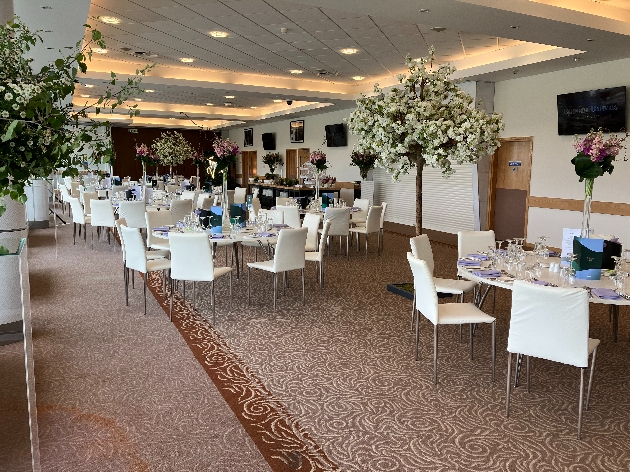 reception room interior cream walls, cream chairs, tables set up 
