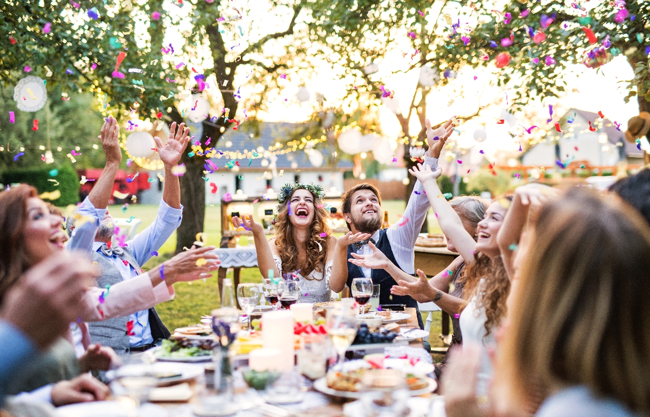 wedding couple and guests at a table outside