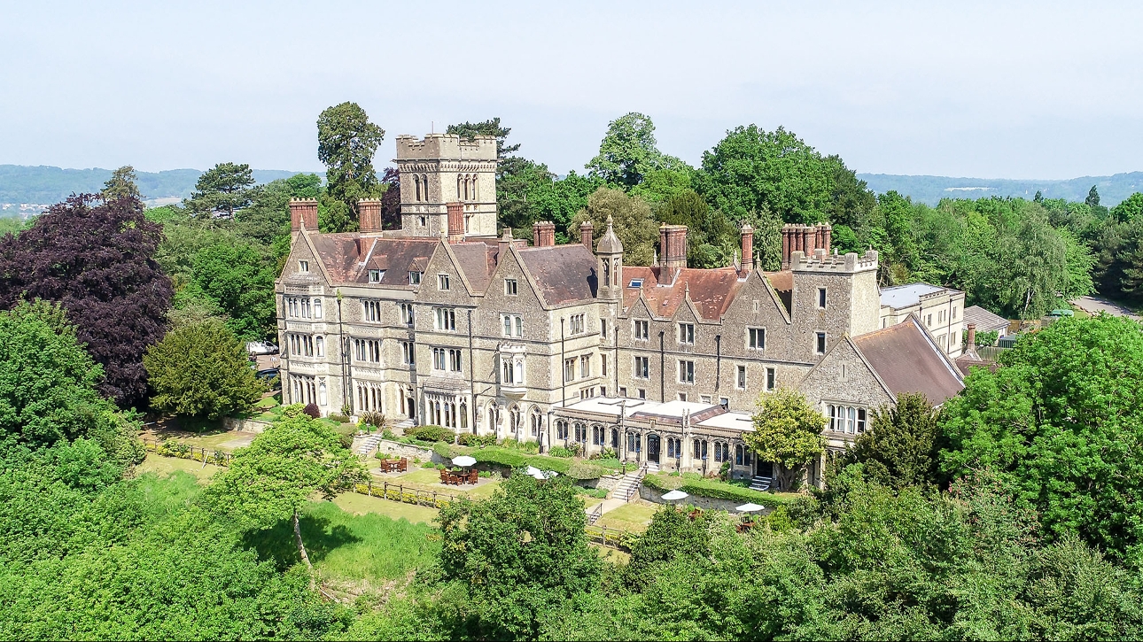 Nutfield Priory historic grey building surrounded by trees