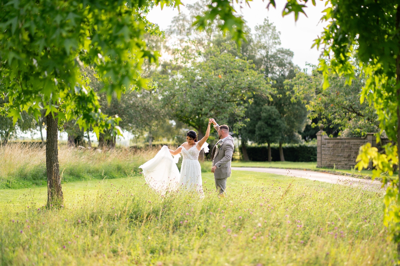 bride and groom dancing in a field