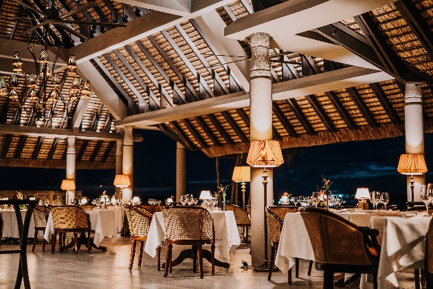 A dining room featuring several tables, chair and romantic lighting