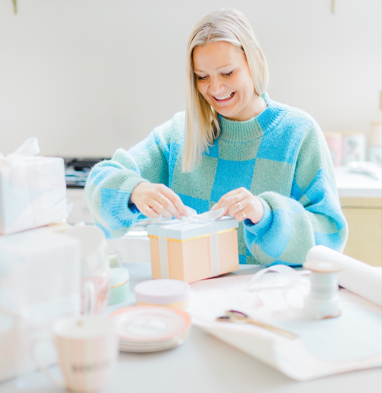 Yvonne Ellen in blue jumper wrapping a gift