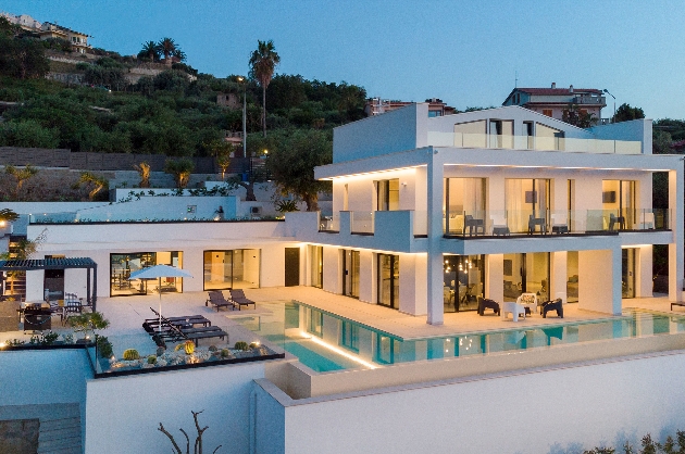 A large white building with an outdoor swimming pool and glass doors