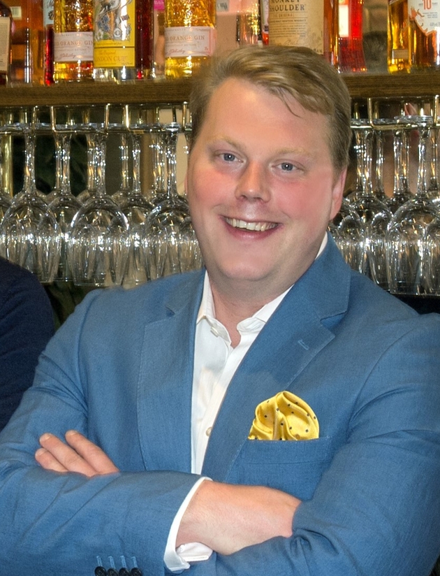 man in suit behind bar