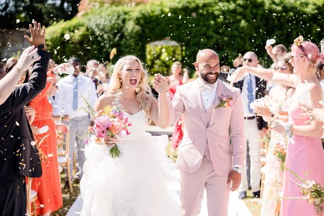 bride and groom walking through confetti throw