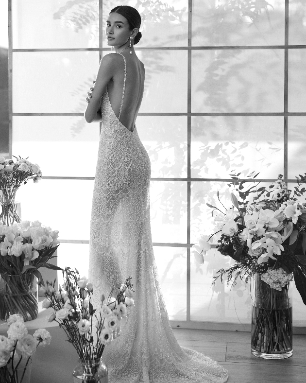 model in beaded lace gown with low back