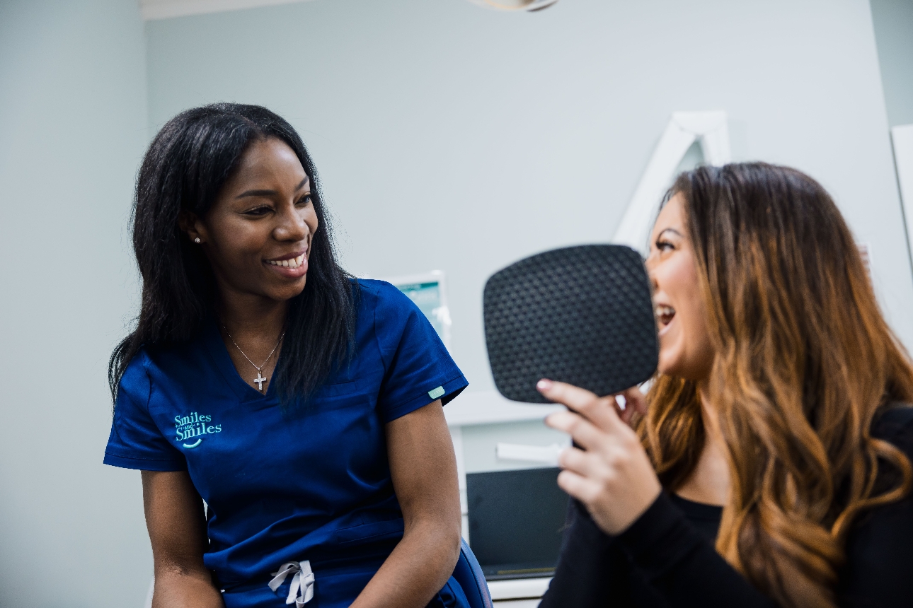 dentist sat in dental room with patient looking in mirror