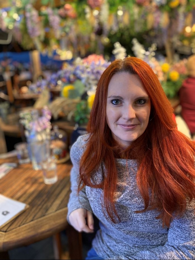 Portrait image of claire sat down at a table