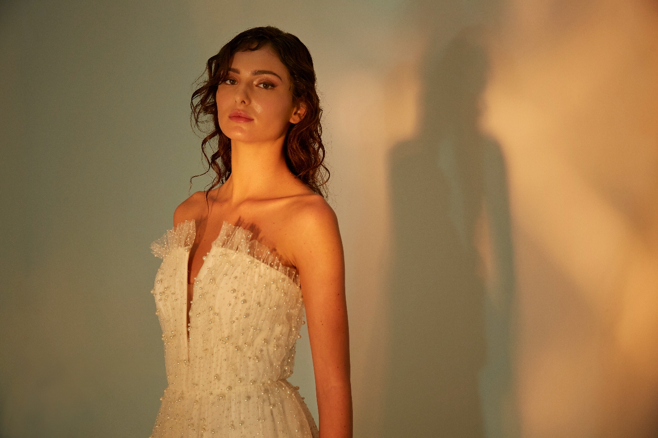 model in wedding dress, with pearl beaded corset, ruffled top to corset