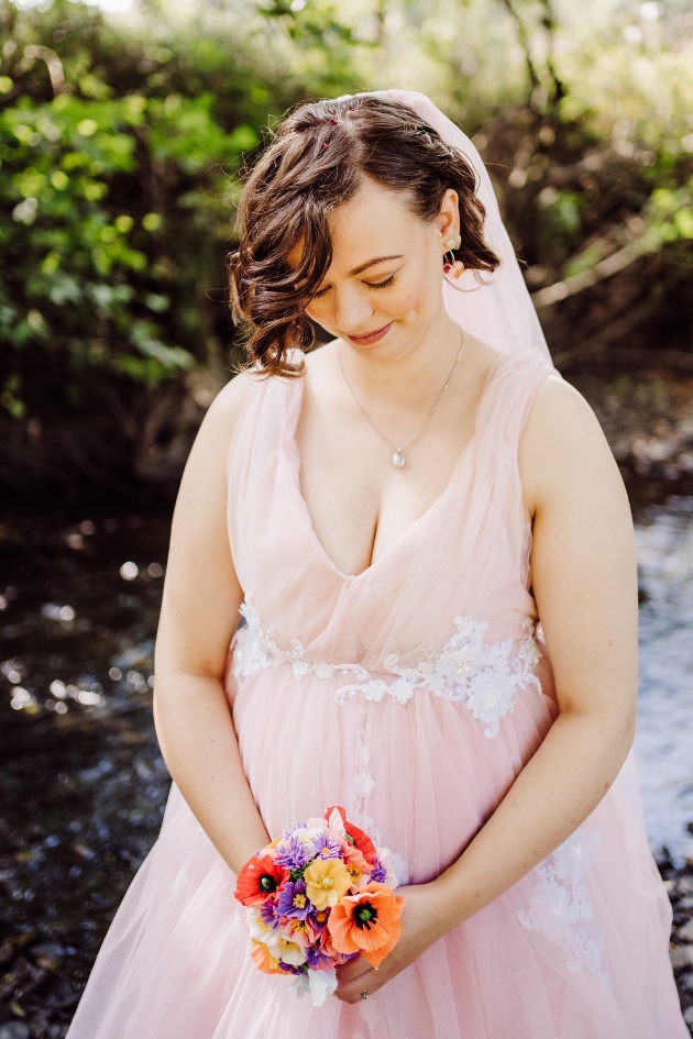 bride in a blush pink dress with white lace detail