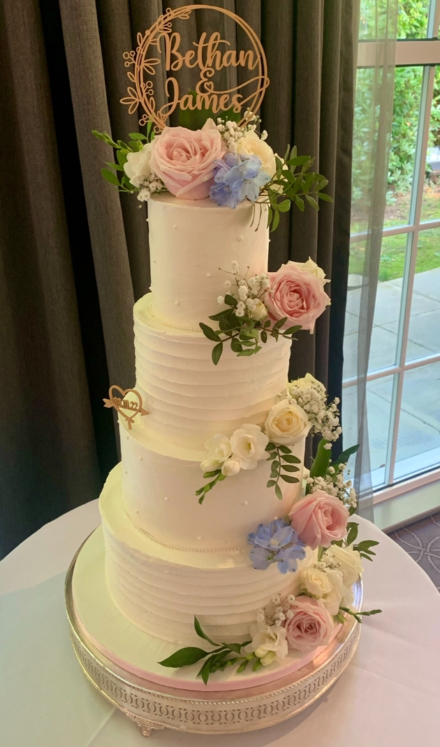 four tie cake in white design with pastel flowers on