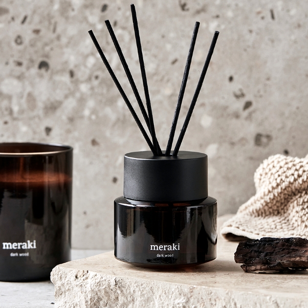 reed diffuser on marble slab with candle in background 