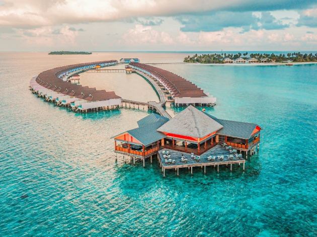 Huts over clear blue water 