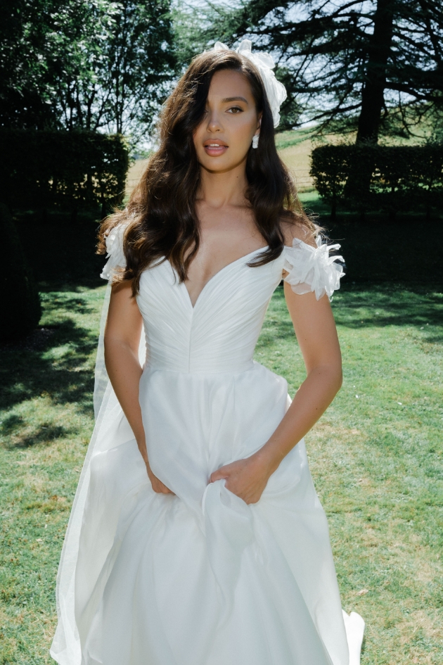woman in big wedding dress posing in field