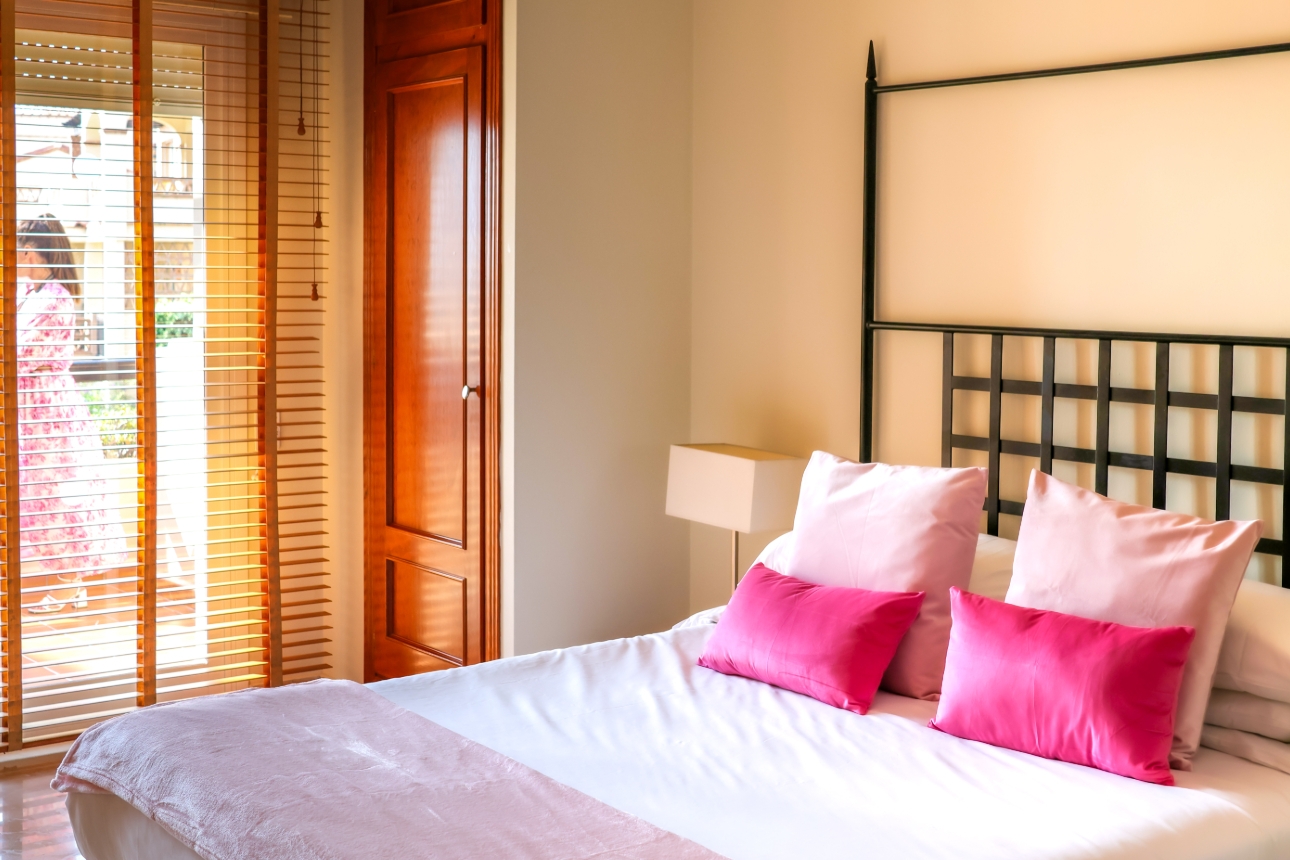 room with pink pillows and blanket