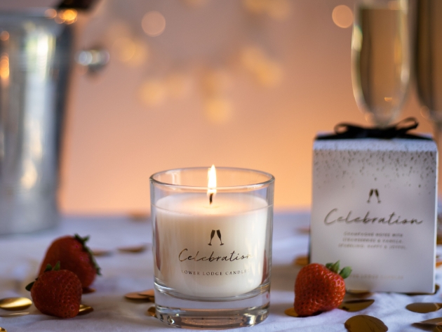 lit candle surrounded by strawberries and fairy lights