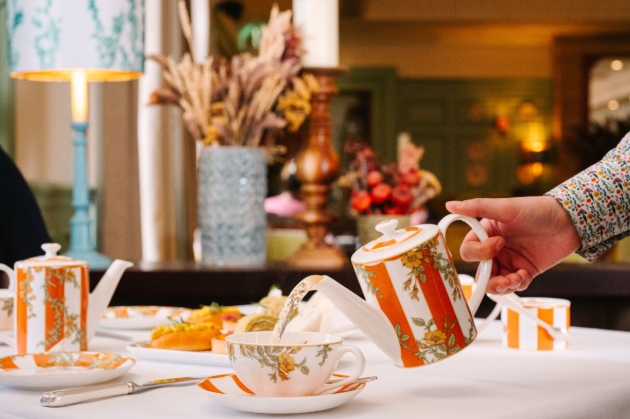 person pouring a cup of tea