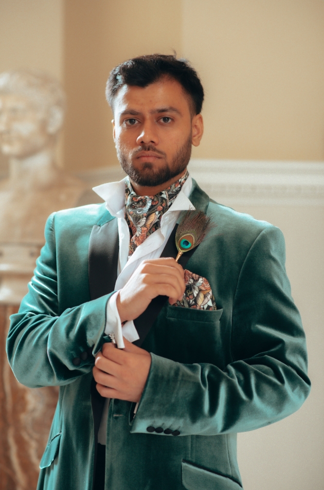 man in green velvet blazer accessories cravat peacock colours