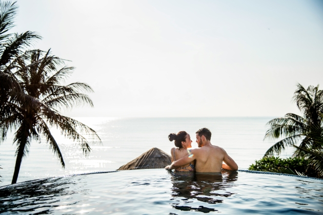 couple in pool looking out to sea